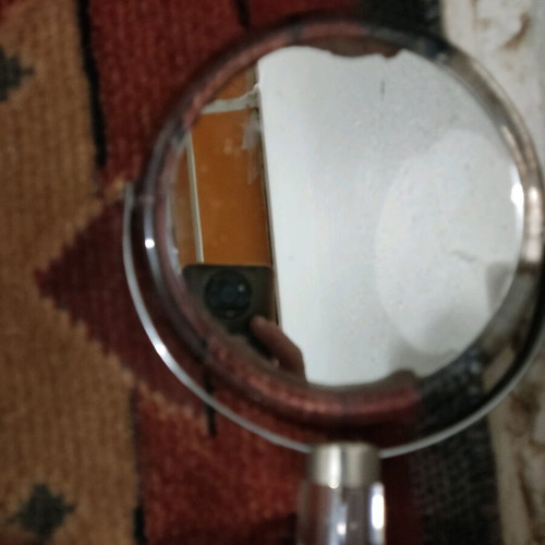 Small mirror used with magnifying side