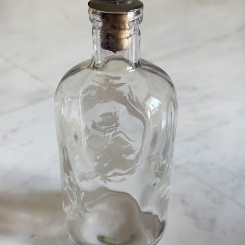 Glass apothecary bottle used with etched floral design