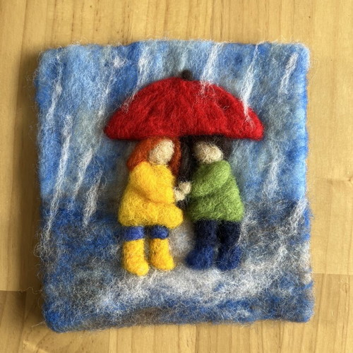 Handmade wool wall art with children under umbrella