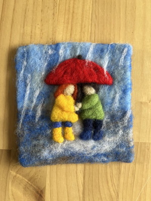 Handmade wool wall art with children under umbrella