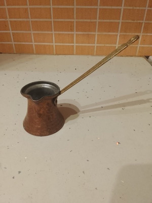 Traditional copper Greek coffee pot used, with long brass handle