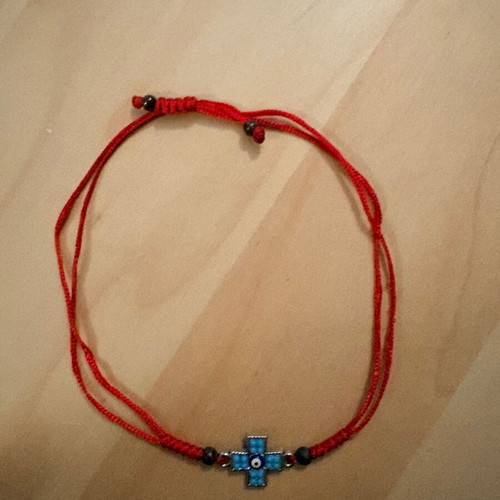 Red bracelet with cross and evil eye charm