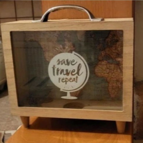 Decorative travel suitcase piggy bank used with map