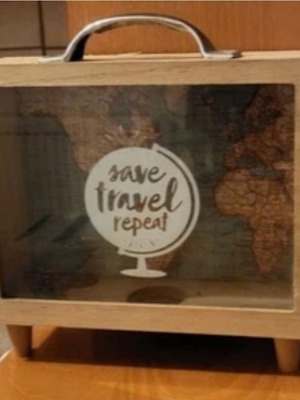 Decorative travel suitcase piggy bank used with map