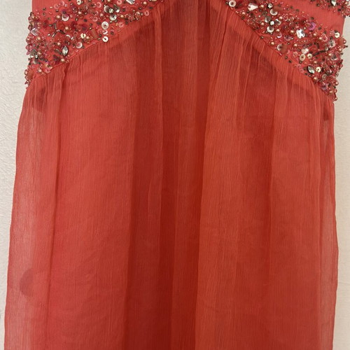 Coral short evening dress with crisscross straps, V neckline, and shiny embroidered beads
