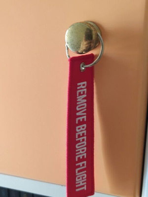 Remove Before Flight keychain new, red