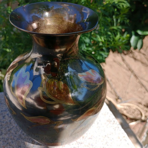 Intricately enameled brass vase with flowers.