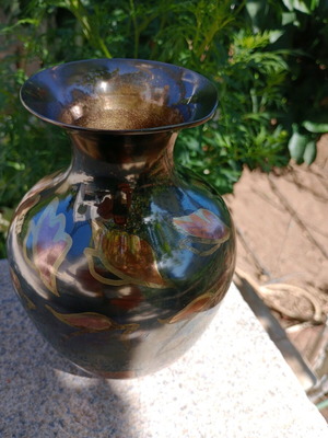 Intricately enameled brass vase with flowers.