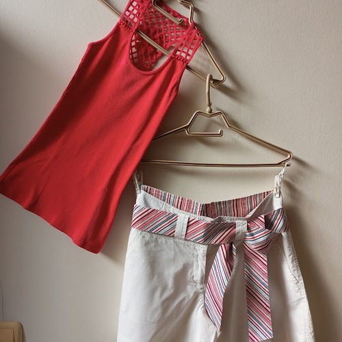 Red sleeveless blouse like new with white shorts and striped belt
