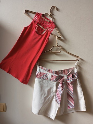 Red sleeveless blouse like new with white shorts and striped belt