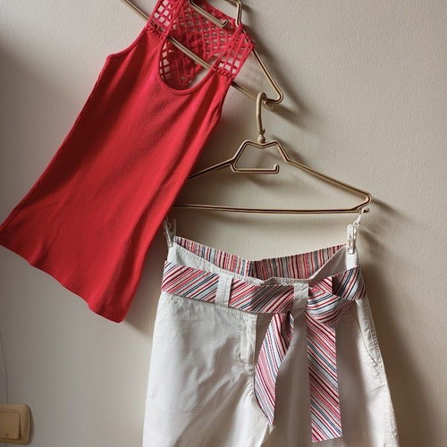 Red sleeveless blouse like new with white shorts and striped belt