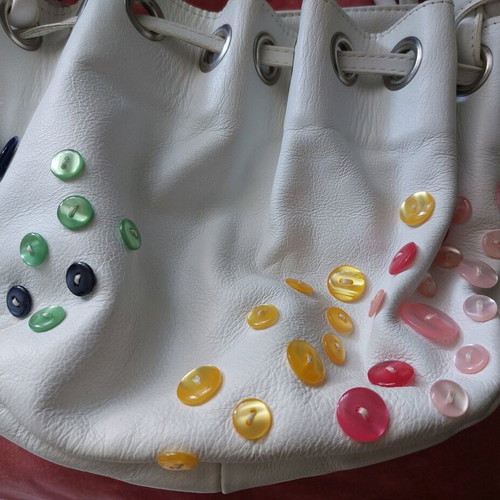 White bucket handbag used with decorative buttons