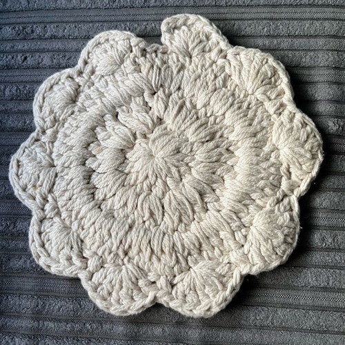 Knitted coaster used, flower-shaped, beige