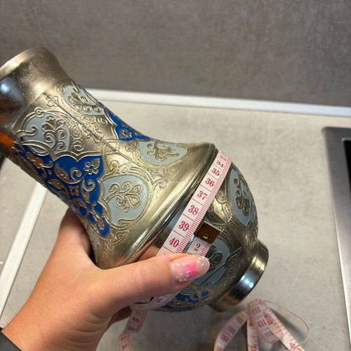 Vintage metal vase used with embossed designs and blue details
