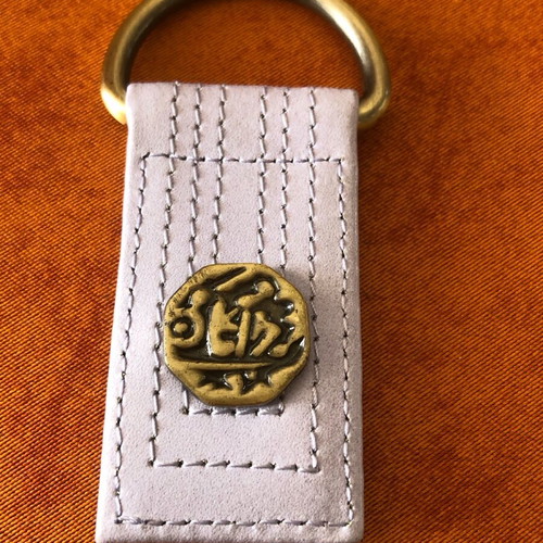 Keychain with intricate design in white, new