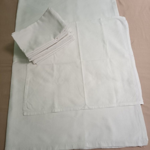 White tablecloth set with 12 used embossed napkins