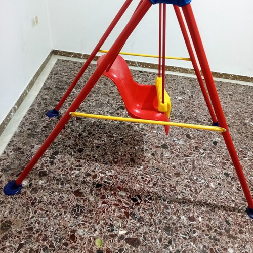 Child swing with metal frame and plastic seat, used with plastic wear