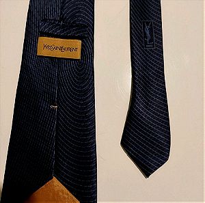 Γραβάτα μεταξωτή YSL( Yves Saint Laurent), 100% μεταξωτή γραβάτα, μπλε σκούρη με σχέδιο γραμμές καμπύλες γκρι, σε άριστη κατάσταση.φορεμένη ελάχιστα.