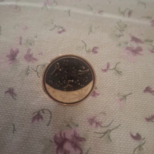 Metal lapel pin with moon and constellation design