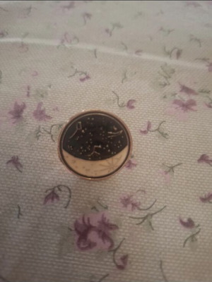 Metal lapel pin with moon and constellation design