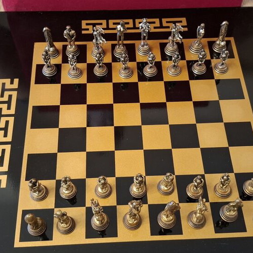 Chess set with decorative metal pieces and black-gold board