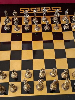 Chess set with decorative metal pieces and black-gold board