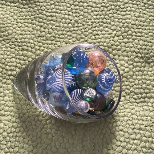 Glass decorative piece with blue sea-themed marbles and stones