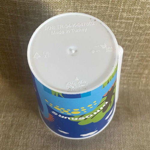 Plastic cup with dinosaur design and straw used