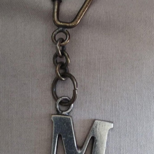 Bronze keychain key holder with monogram M on chain used