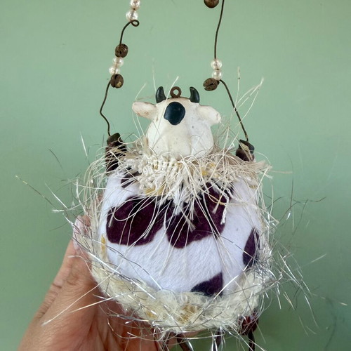 Hanging decorative ornament with fabric and ceramic cow