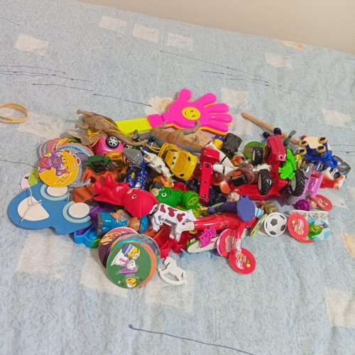 Box of various used children's toys including pop-it and wooden drum