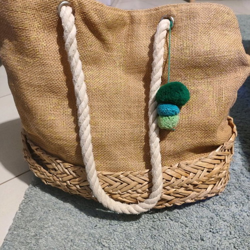 Straw shoulder bag used with pom poms and rope straps beige