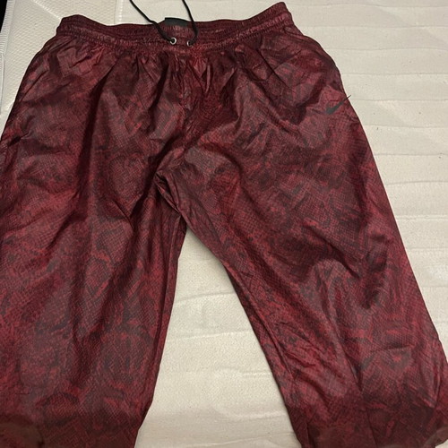 Nike snake print pants with signs of wear