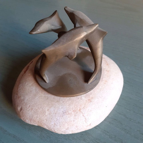 Decorative composition with three bronze dolphins used, on stone