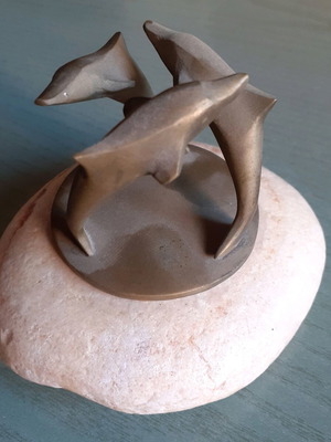 Decorative composition with three bronze dolphins used, on stone