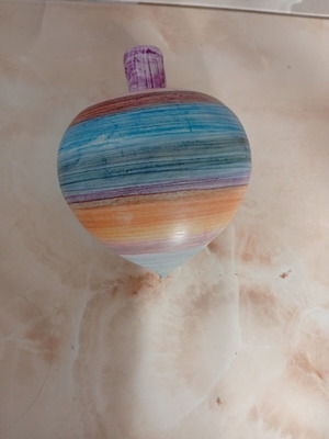 Decorative traditional handmade clay spinning top with colorful stripes