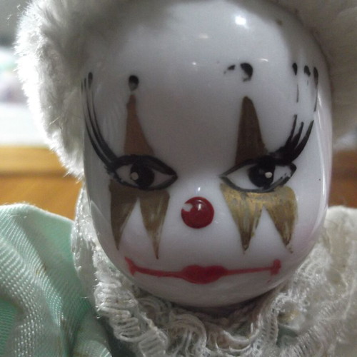 Porcelain clown doll used with white and green satin costume
