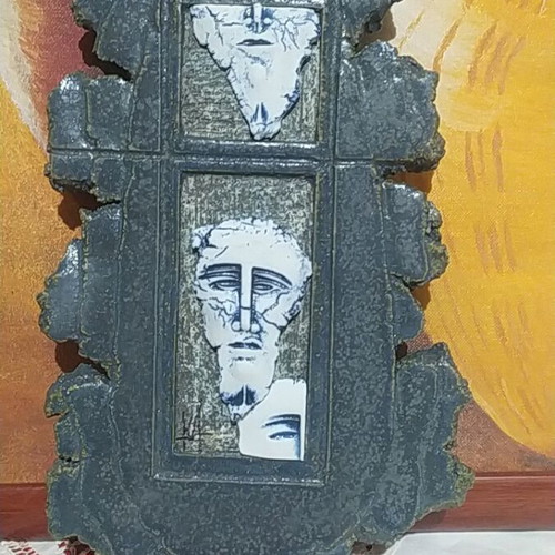 Handmade stone wall decoration with embossed ancient-style faces