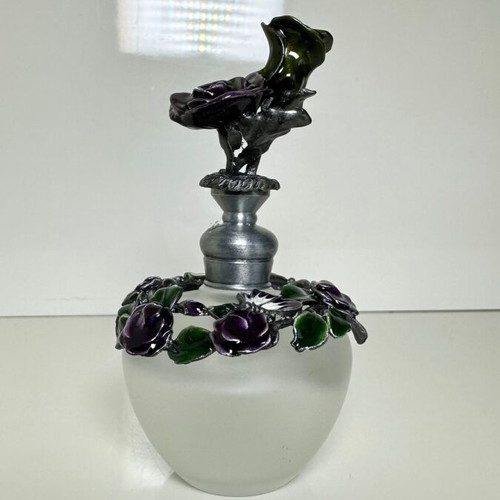 Vintage ornate perfume bottle with frosted glass and metal floral decoration