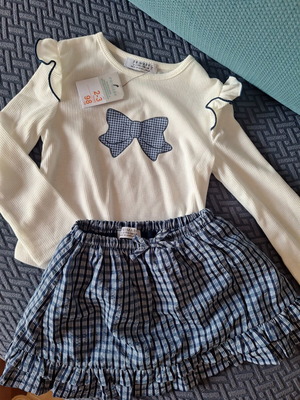 Primark toddler set with white long-sleeve top and blue check skirt