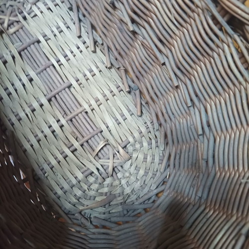 Handmade dark brown wicker basket with high arched handle