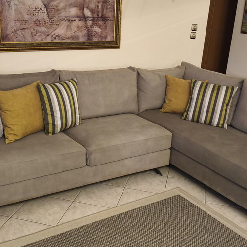 Corner sofa like new in grey/beige taupe color with decorative pillows