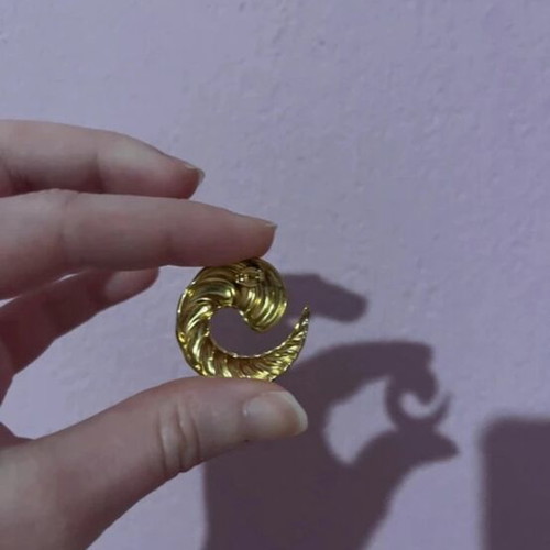 Gold earrings in snake, crescent, and spiral shapes like new