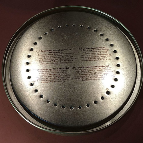 Metal biscuit tin with moisture-absorbing lid
