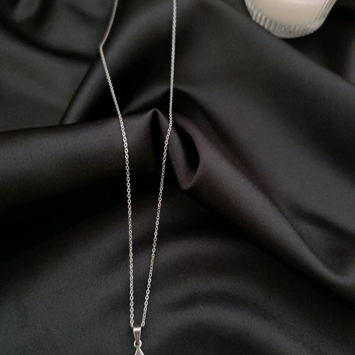 Minimal handmade steel chain necklace with a triangle pendant featuring a carved eye