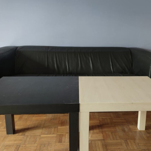 Black leather three-seater sofa used with coffee tables