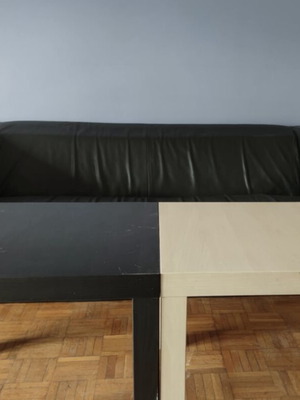 Black leather three-seater sofa used with coffee tables