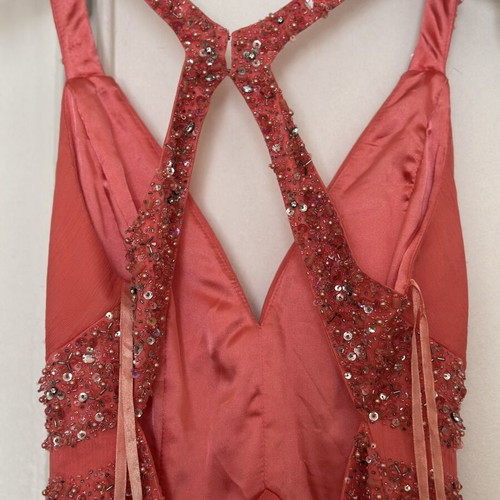 Coral short evening dress with crisscross straps, V neckline, and shiny embroidered beads