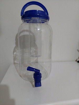Cocktail dispenser used, plastic jar with blue lid and tap