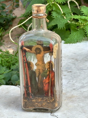 Vintage decorative bottle with handmade religious crucifixion diorama used